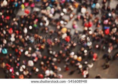Blurred crowd of people in multicolored clothes in the city. Top view