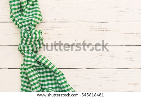 Green table cloth on white wooden background.