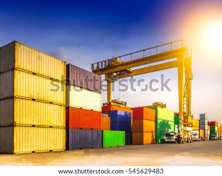 The RTG(Rubber Tried Gantry Cranes) pick up full loaded containers on truck at industrial port and container yard   for delivery to customers Royalty-Free Stock Photo #545629483