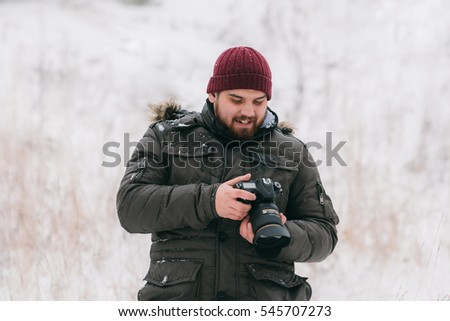 Male photographer taking pictures in winter environment