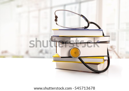 medical education - stack of books with stethoscope on the table in library Royalty-Free Stock Photo #545713678