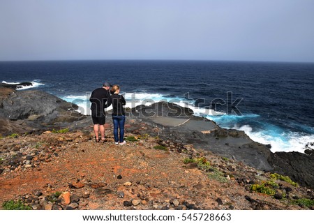 Loving couple admiring stormy sea