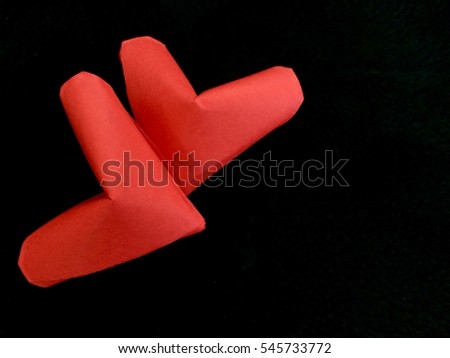 Two Folding paper red hearts isolated on black background. You can use for greeting card for Valentine's Day with Text [Happy Valentine's Day]