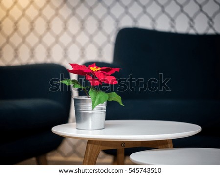 interior with black sofa and small white table on wooden legs and a small pot