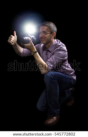 Male paparazzi or editorial photographer journalist using a speedlight flash strobe in the dark
