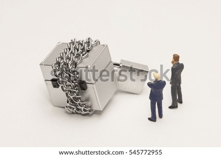 Businessman looking at boxes tied with chains