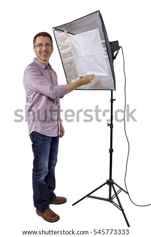 Male photographer showing or demonstrating how to use a soft box studio light for photography on a white background.