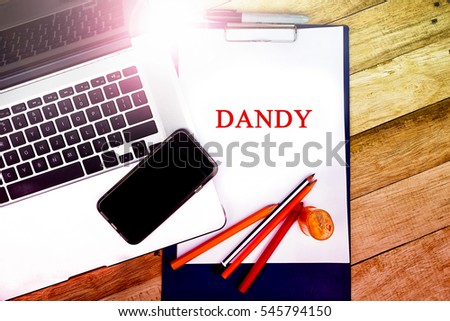 DANDY word, text at notepad in wooden table background , retro concepts in wooden with notebook and smartphone