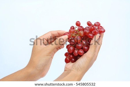 Hand holding bunch red grape on white background.