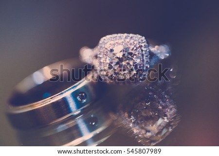 Wedding rings on reflective glass.