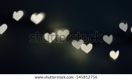 Bokeh lights, in the shape of little hearts against midnight blue.