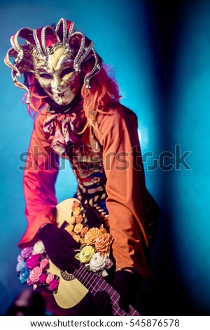 Actor in a Venetian costume playing the guitar in beautiful colors. Romantic musician.
