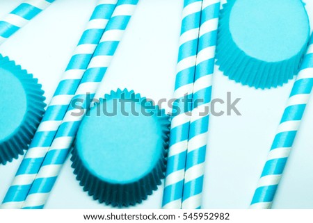 Baby blue straws and cupcake papers. Party background.