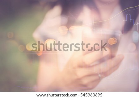 Business economic and technology working concept. Woman using smart phone in park double exposure graph money stock trading and blur bokeh light background. Vintage tone filter effect color style.