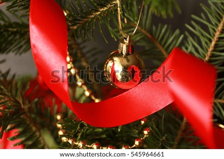 Red christmas ornaments, on the xmas tree on glitter bokeh background with twinkle lights. Merry christmas card. Winter holiday theme. Happy New Year.