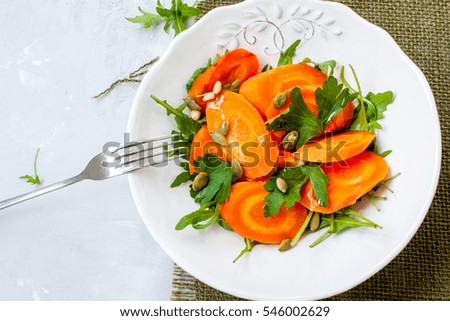 Simple salad of baked carrots with arugula and butter. Vegan healthy lunch or dinner.