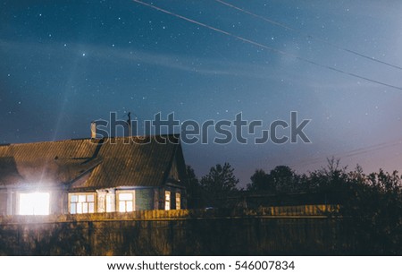 Blue dark night sky with many stars and house in village 
