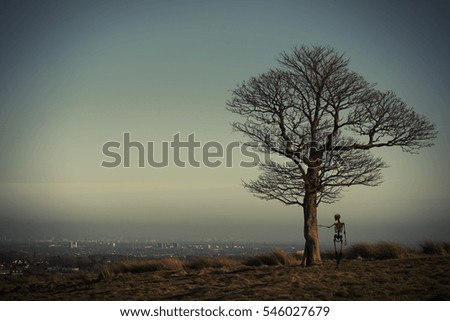 Skeleton standing next to the lonely oak tree




