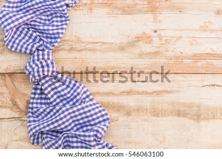 Blue tablecloth on old rustic wooden table background.