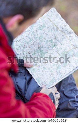 Cropped image of male hiker reading map