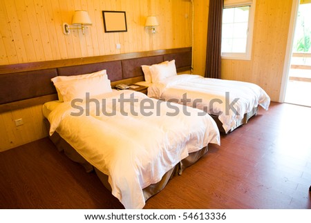 Wooden hotel room with two beds.