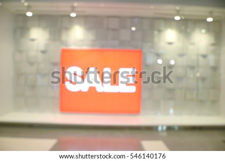 Sale banner, white and red color, at fashion store in shopping mall, abstract blur background