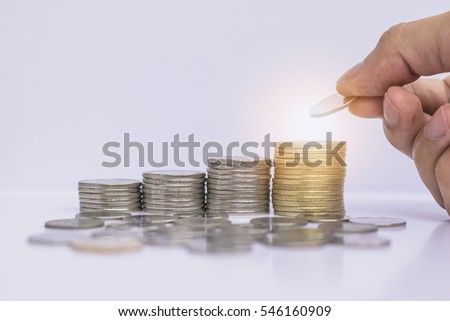 Hand put coin on the stack of coin