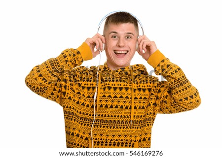 Young happy Caucasian man smiling while listening to music isolated against white background
