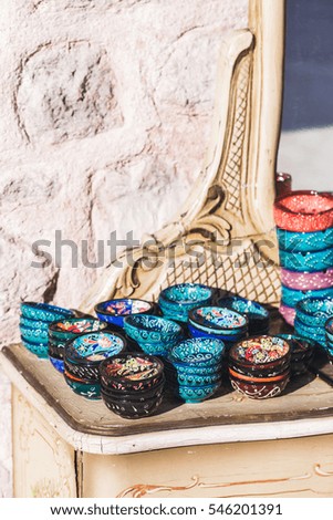 Stack of handmade multicolor Turkish dishes painted with oriental ornaments. Vintage plates on wooden table