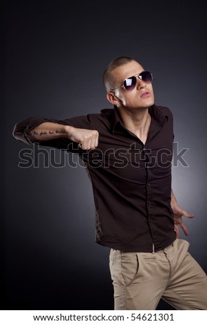 picture of a young fashion man in a fight position over dark background