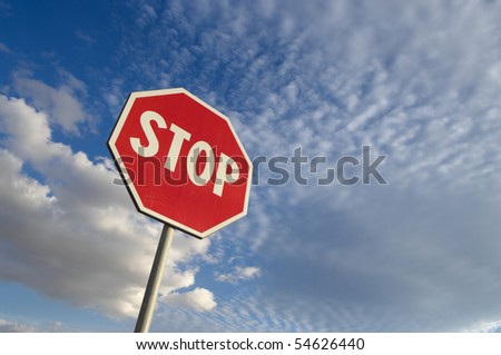 stop sign against blue sky and white clouds