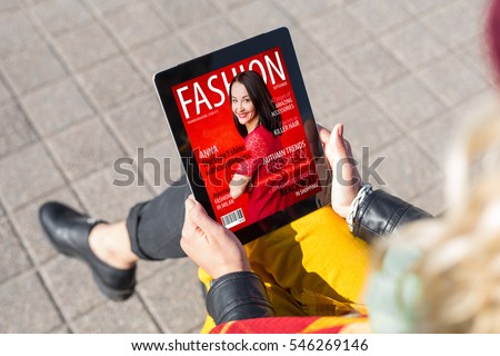 Woman reading fashion magazine on tablet