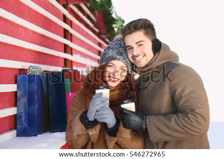 Woman and man drinking coffee on Christmas market