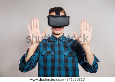 emotional funny man wearing virtual reality goggles. Studio portrait of video game designer wearing VR headset. studio shot isolated on gray background.