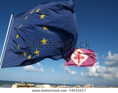 the flag of Florence and the European Union against the background of the deep blue sky.