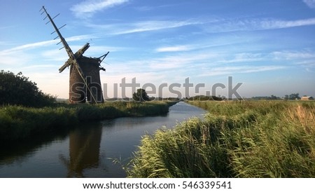 Landscape with windmill on a bright late Summer Day on the Norfolk Broads in East Anglia Norfolk Royalty-Free Stock Photo #546339541