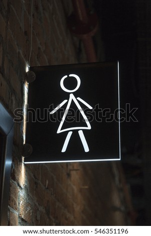 Black and white icon indicating the direction to the toilet