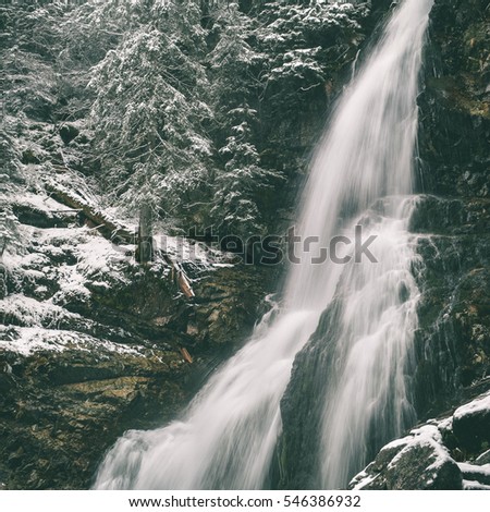 Waterfall from ravine in winter, long exposure, in mountain river with rocks - instant vintage square photo