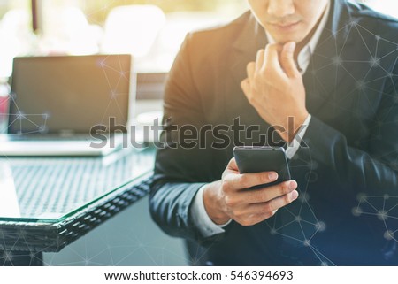 Close up handsome young man using smart phone . Business texting. Serious young businessman holding mobile phone and looking .