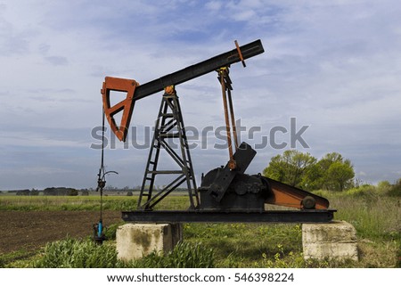 Small oil derrick pumps petroleum on the field, Bulgaria