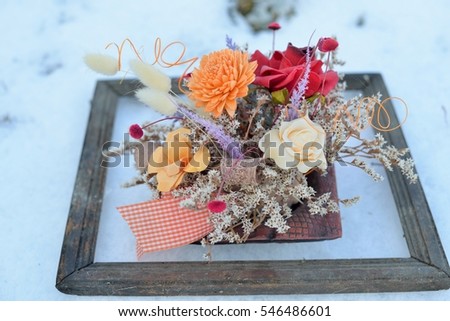 3d picture in nature. Dried flowers in a very old photo frame on snow