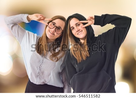 Happy twin sisters on unfocused background