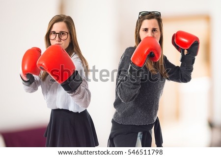 Twin sisters with boxing gloves on unfocused background