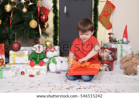 Little boy after the New Year's Eve opens a gift