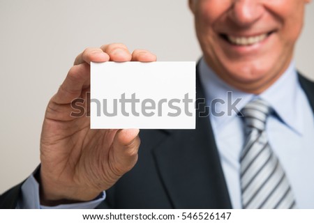 Smiling mature man holding a blank business card