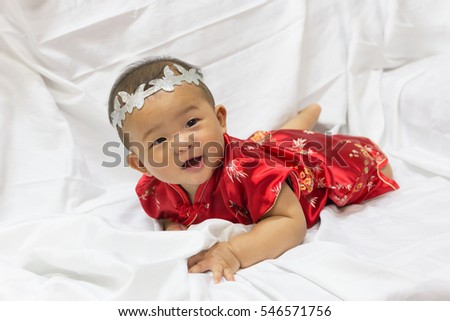 Asian cute new born girl baby with gesture of congratulation happy chinese new years.