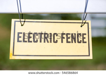Electric fence sign held up with wire
