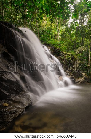 Kanching Waterfall in Malaysia. The photo have a soft focus or blurry image due to the slow shutter speed to obtain the silky water flow affect