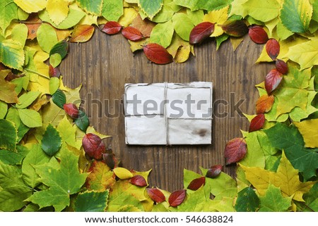 autumn leaves background in shape of heart on wooden table