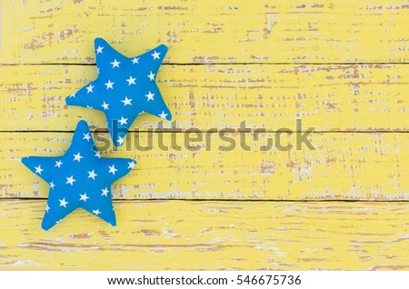 Blue star shapes on wooden background.